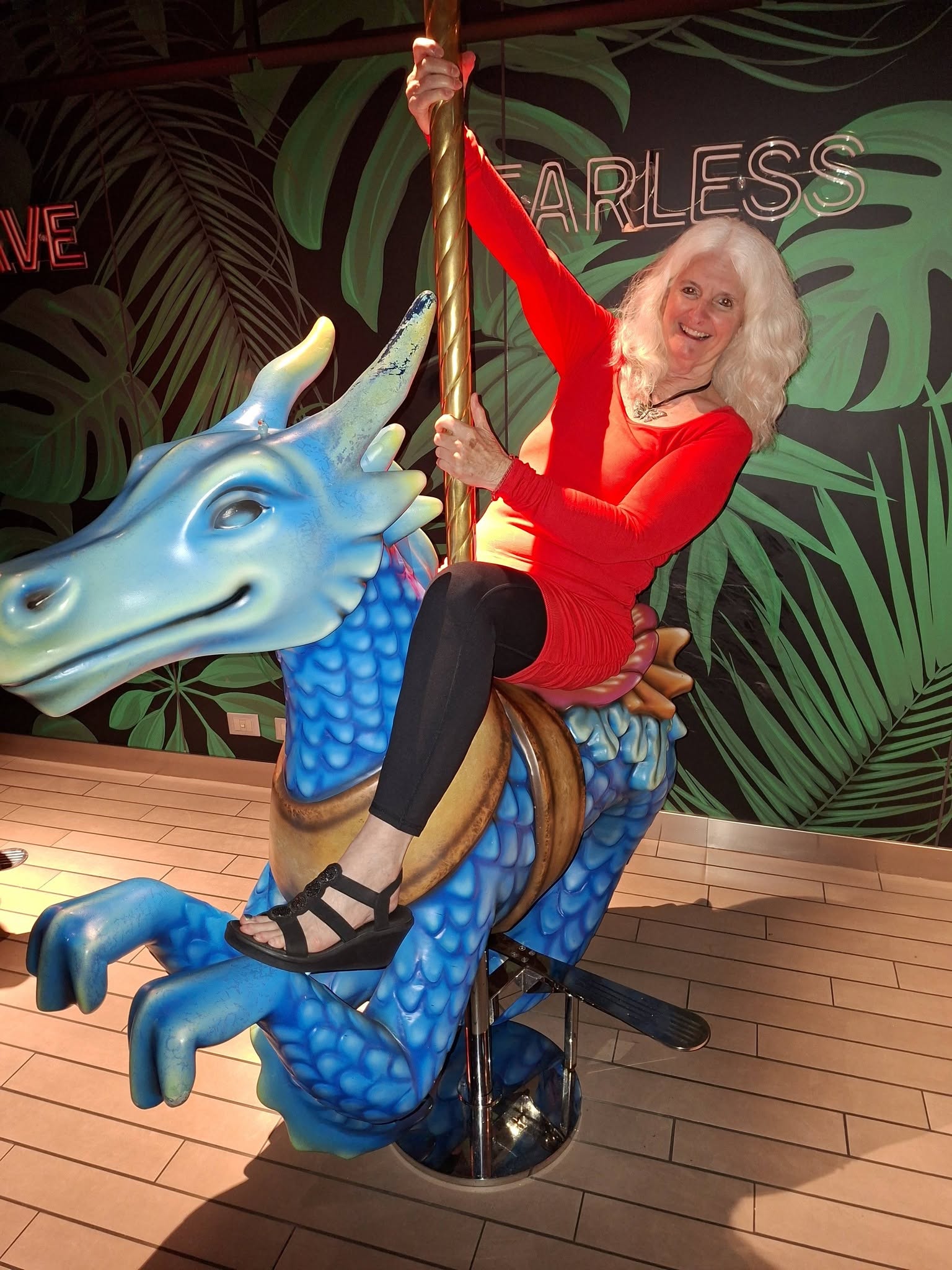 Judy riding a blue dragon aboard Virgin Voyages